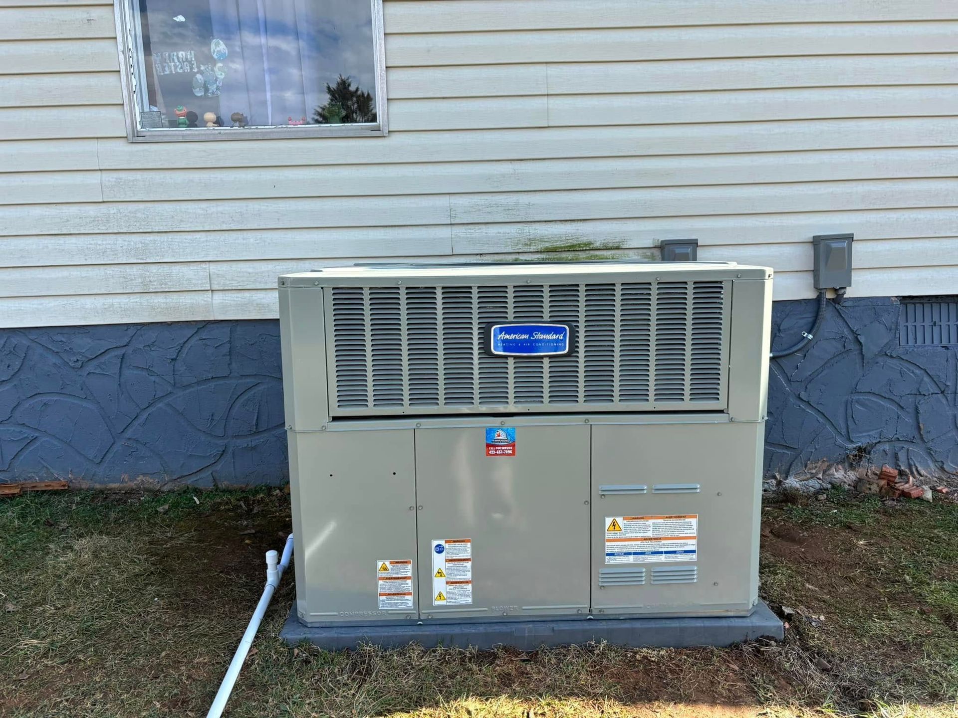 An air conditioner is sitting on the side of a house.