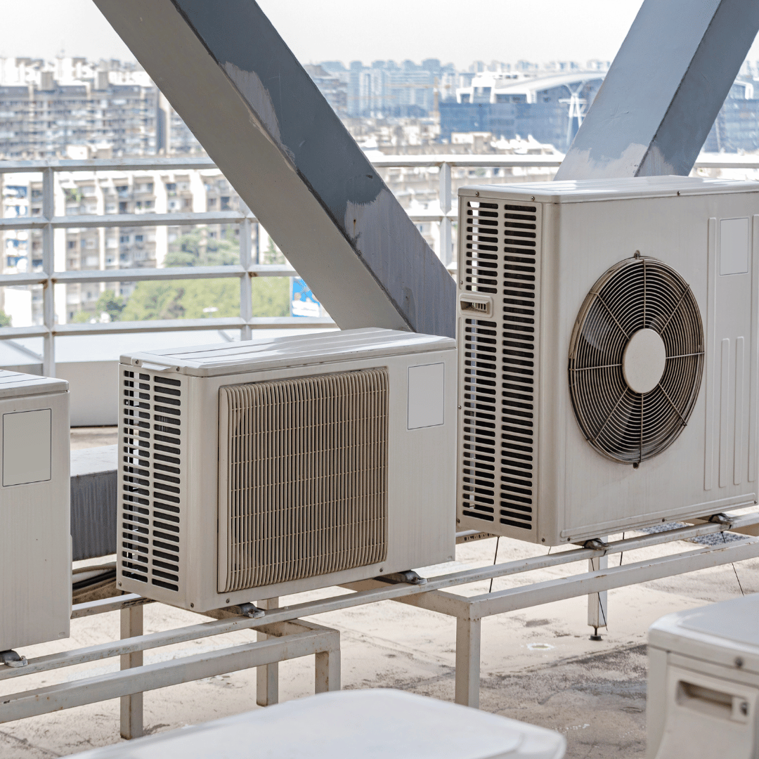A bunch of air conditioners are sitting on top of a roof.
