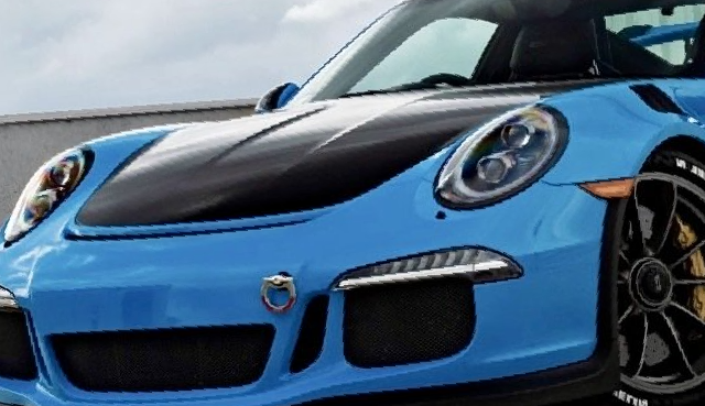 a blue porsche 911 gt3 rs is parked in front of a building .