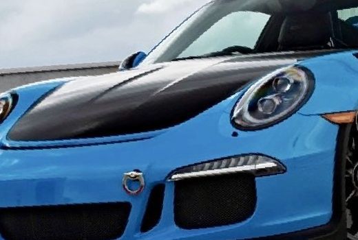 a blue porsche 911 gt3 rs is parked in front of a building .