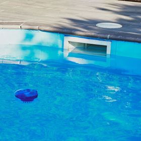 Un oggetto blu galleggia in una piscina.