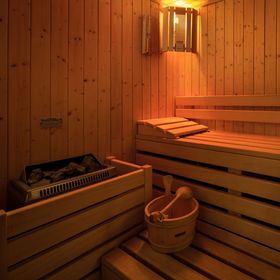 Una sauna in legno con un secchio sulla panca