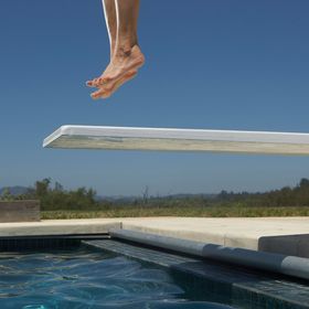 Una persona sta saltando da un trampolino in una piscina