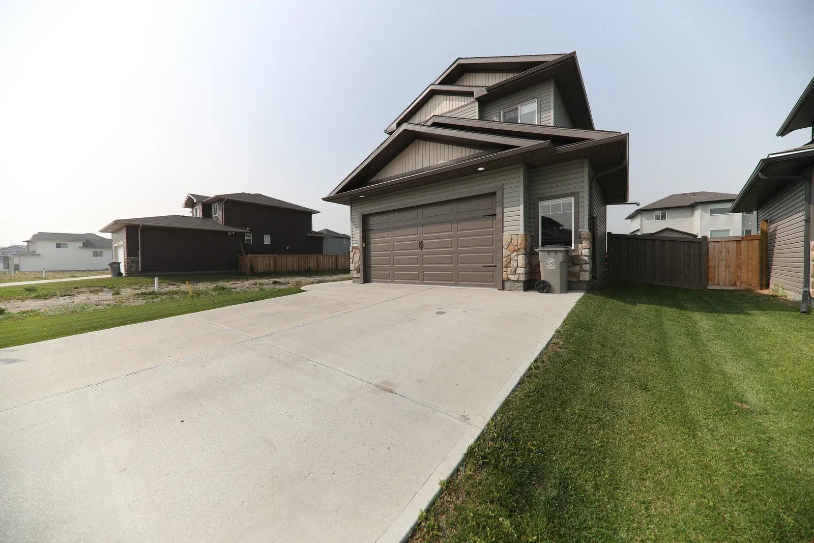 A large house with a garage and a driveway in front of it.