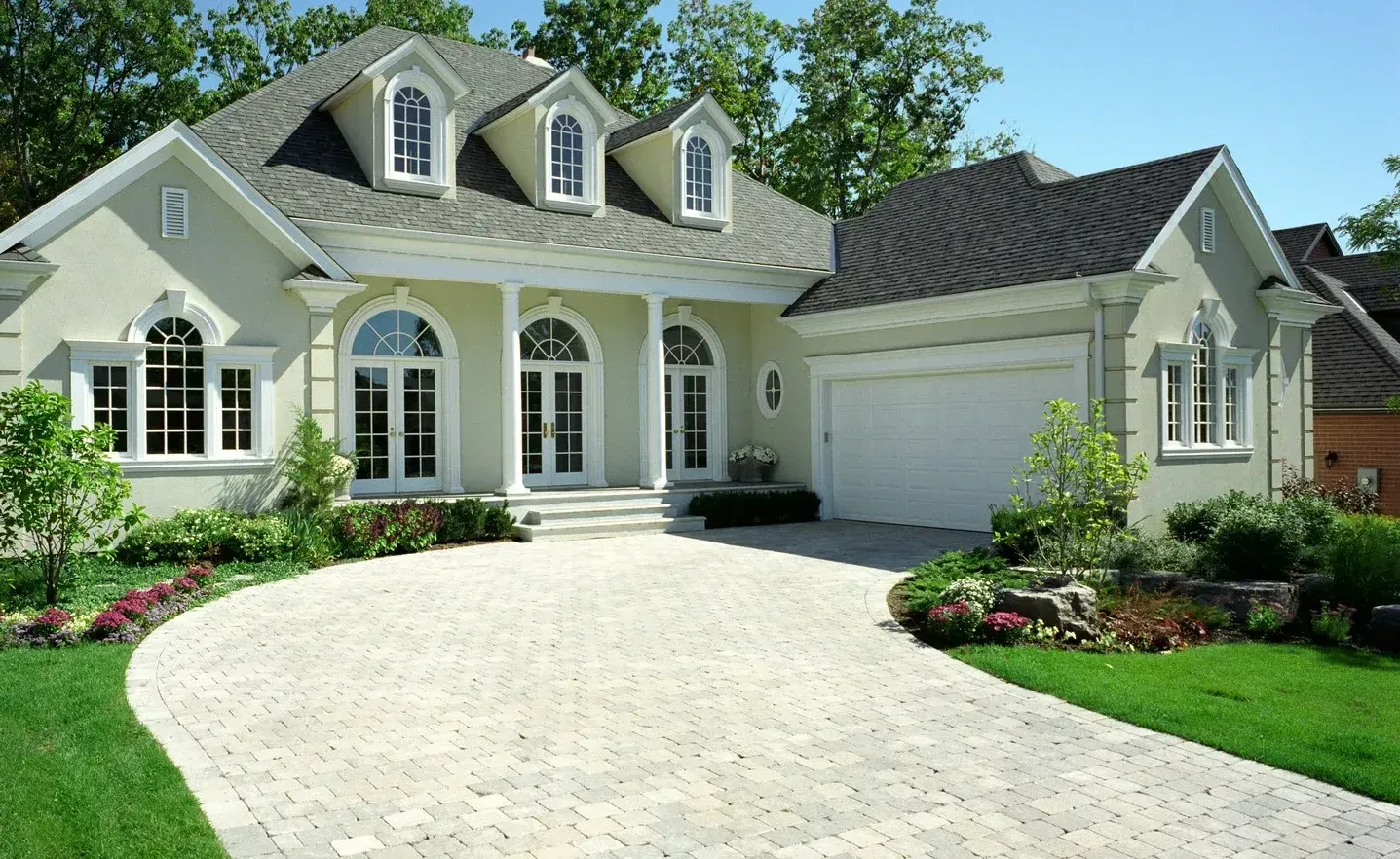 A large white house with a driveway leading to it