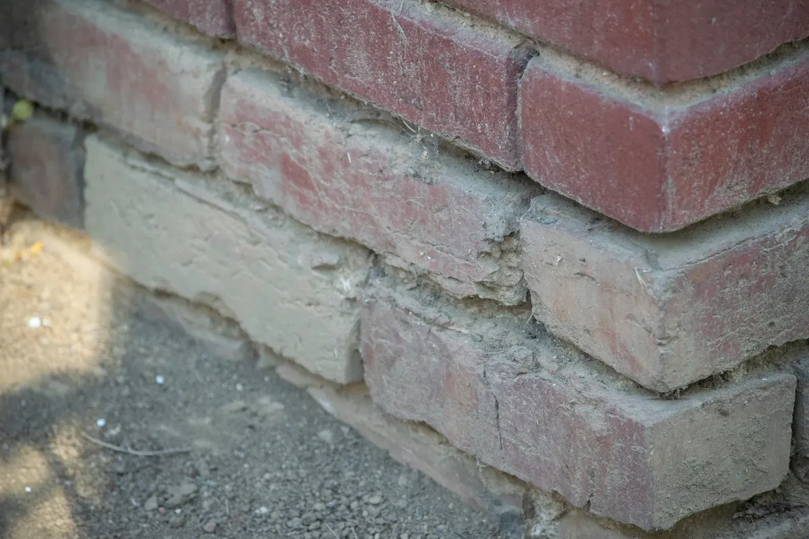 A man is laying bricks on a wall with a trowel.