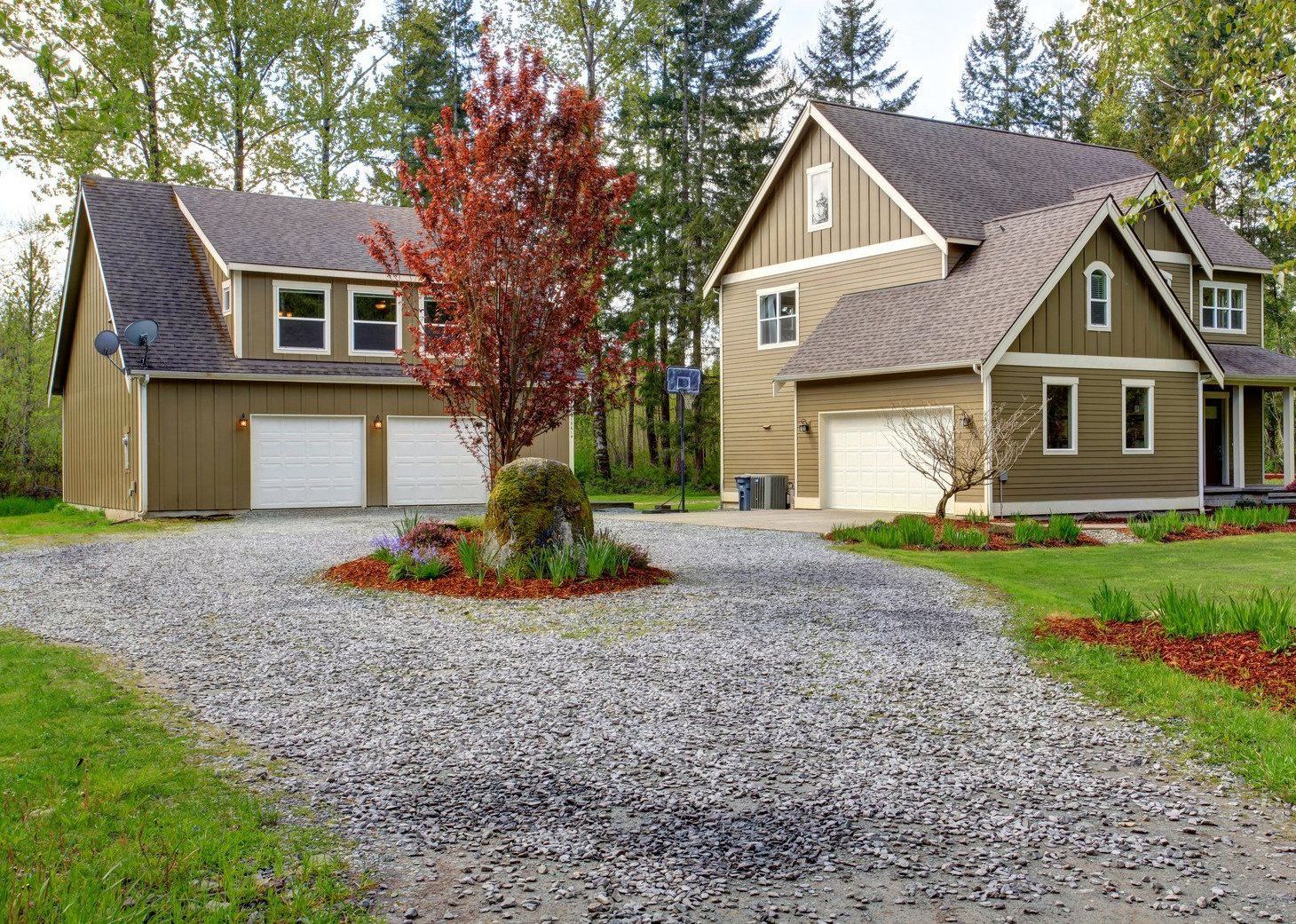 A large house with a gravel driveway in front of it