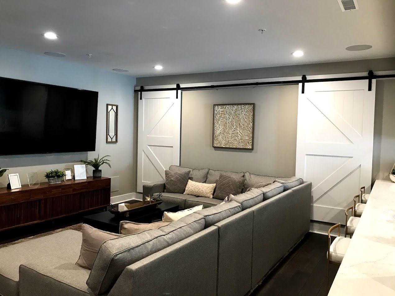 A living room with a large sectional couch and a flat screen tv.
