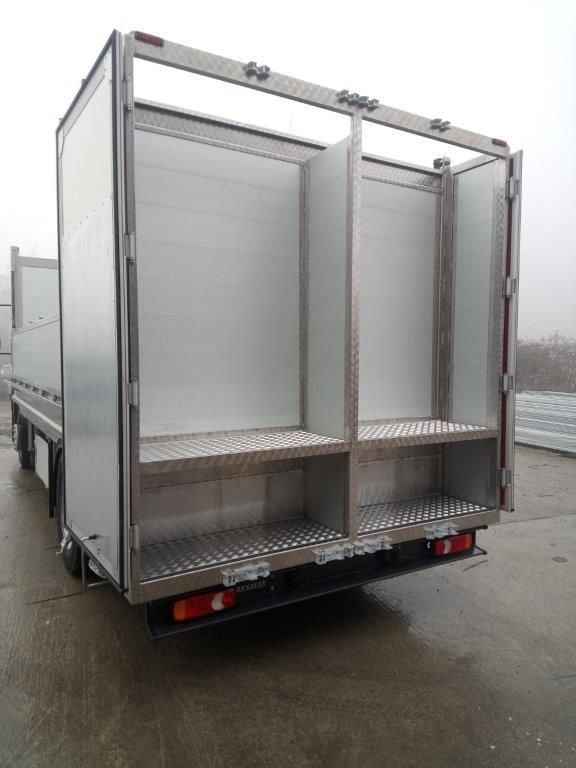 Vista posteriore di un furgone con le porte aperte che mostra un interno vuoto diviso da una parete divisoria verticale e da un pavimento in lamiera mandorlata.