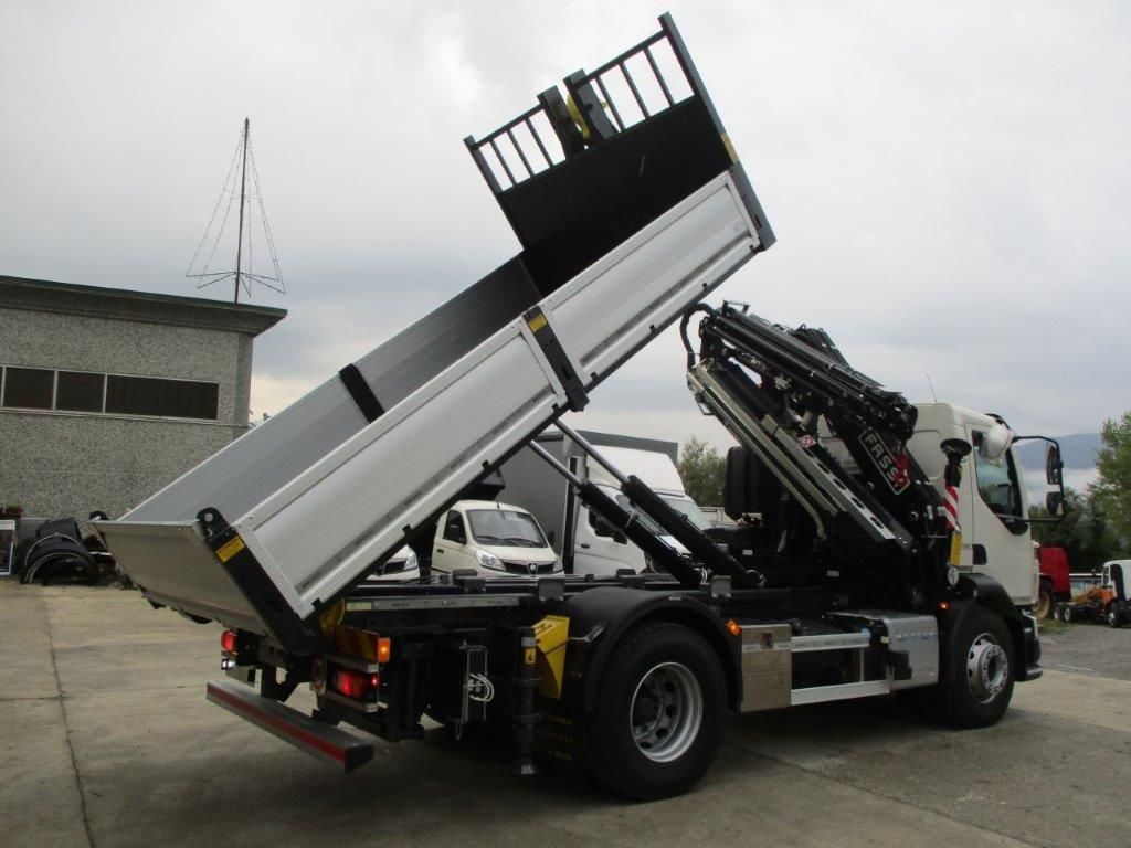 Un autocarro ribaltabile bianco con gru è parcheggiato all'aperto, con il cassone sollevato e inclinato in posizione di scarico.