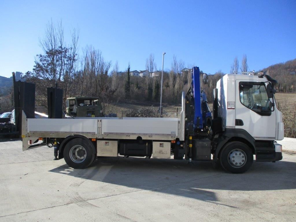 Un camioncino bianco con pianale e gru blu montata, parcheggiato all'aperto su un piazzale asfaltato in una giornata di sole.