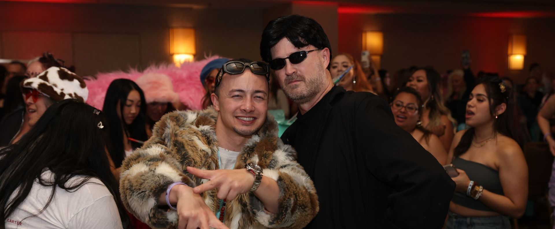 Two men are posing for a picture at a party.