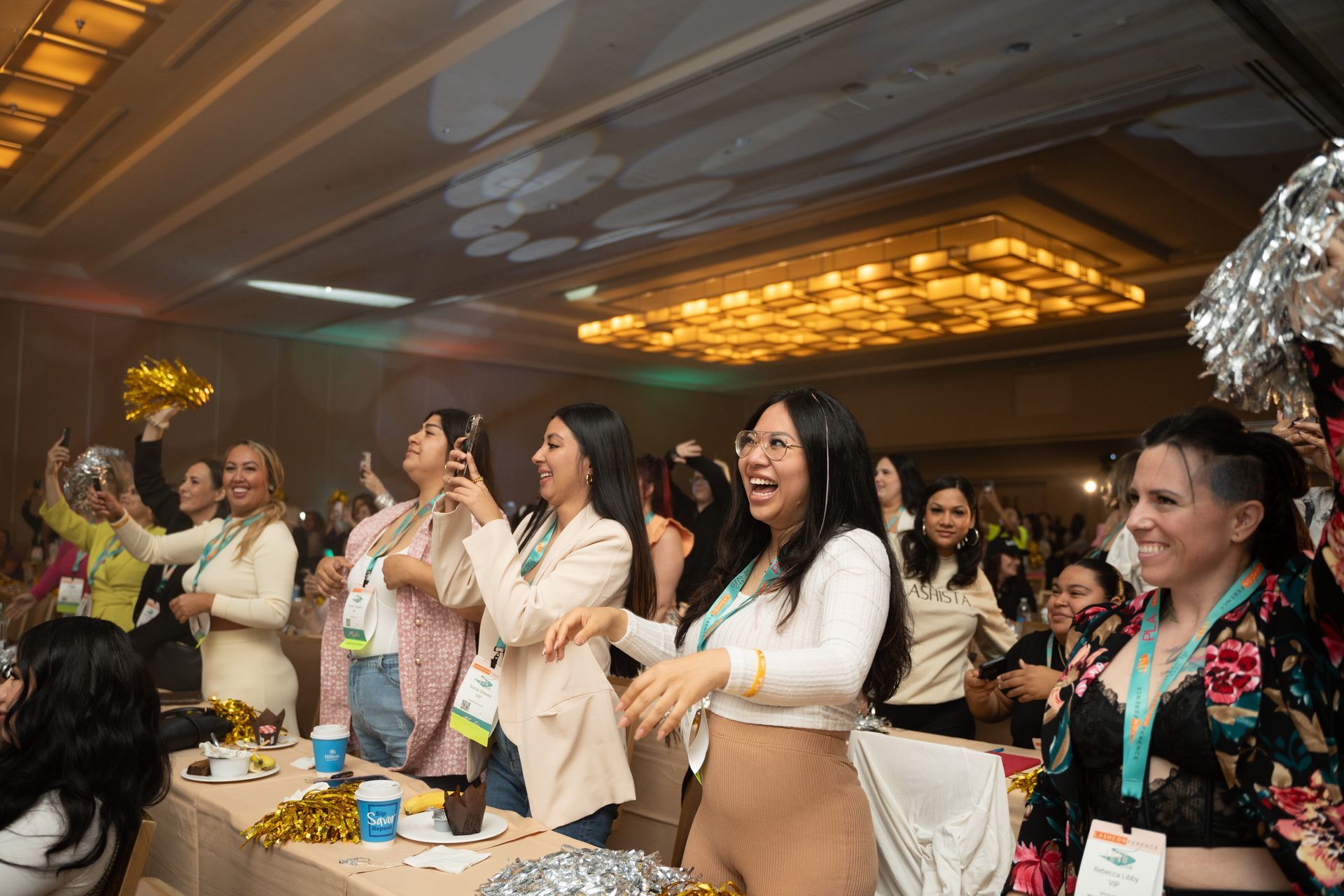A group of women are dancing in a room at a conference.