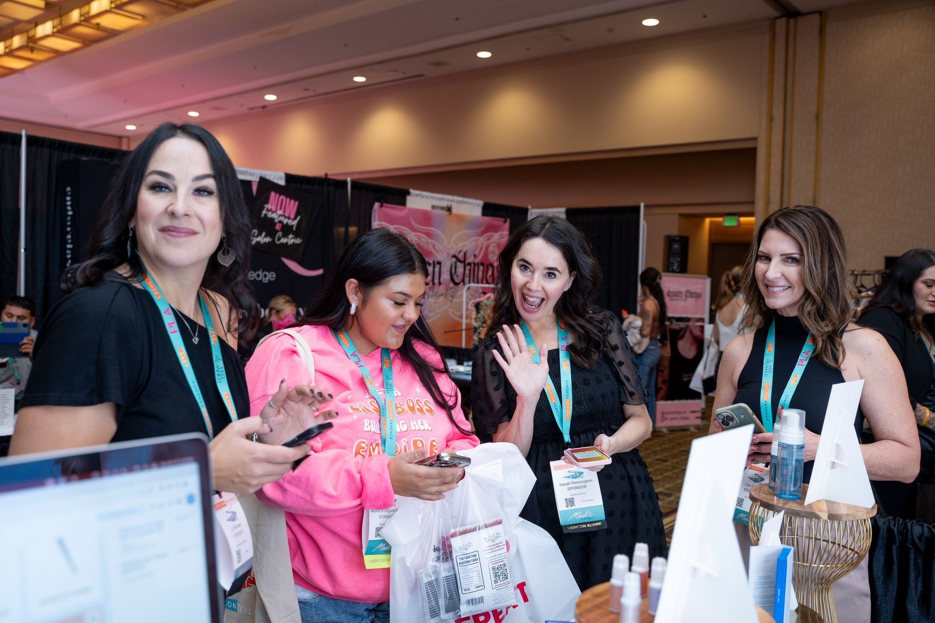 A group of women are standing around a table at a convention.