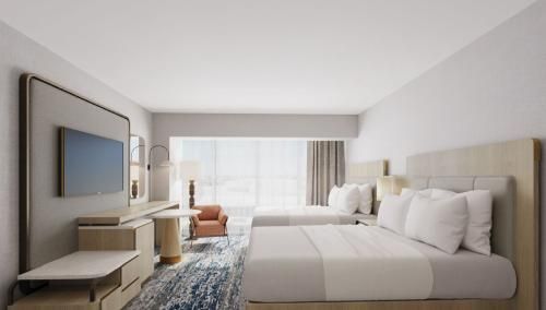 A hotel room with two beds and a flat screen tv.