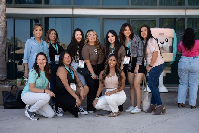 A group of women are posing for a picture in front of a building.