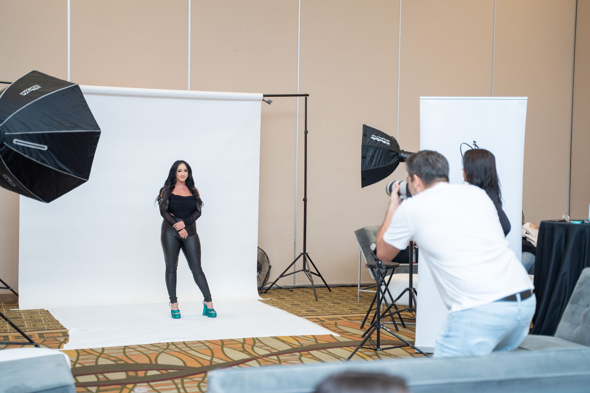 A man is taking a picture of a woman in a photo studio.