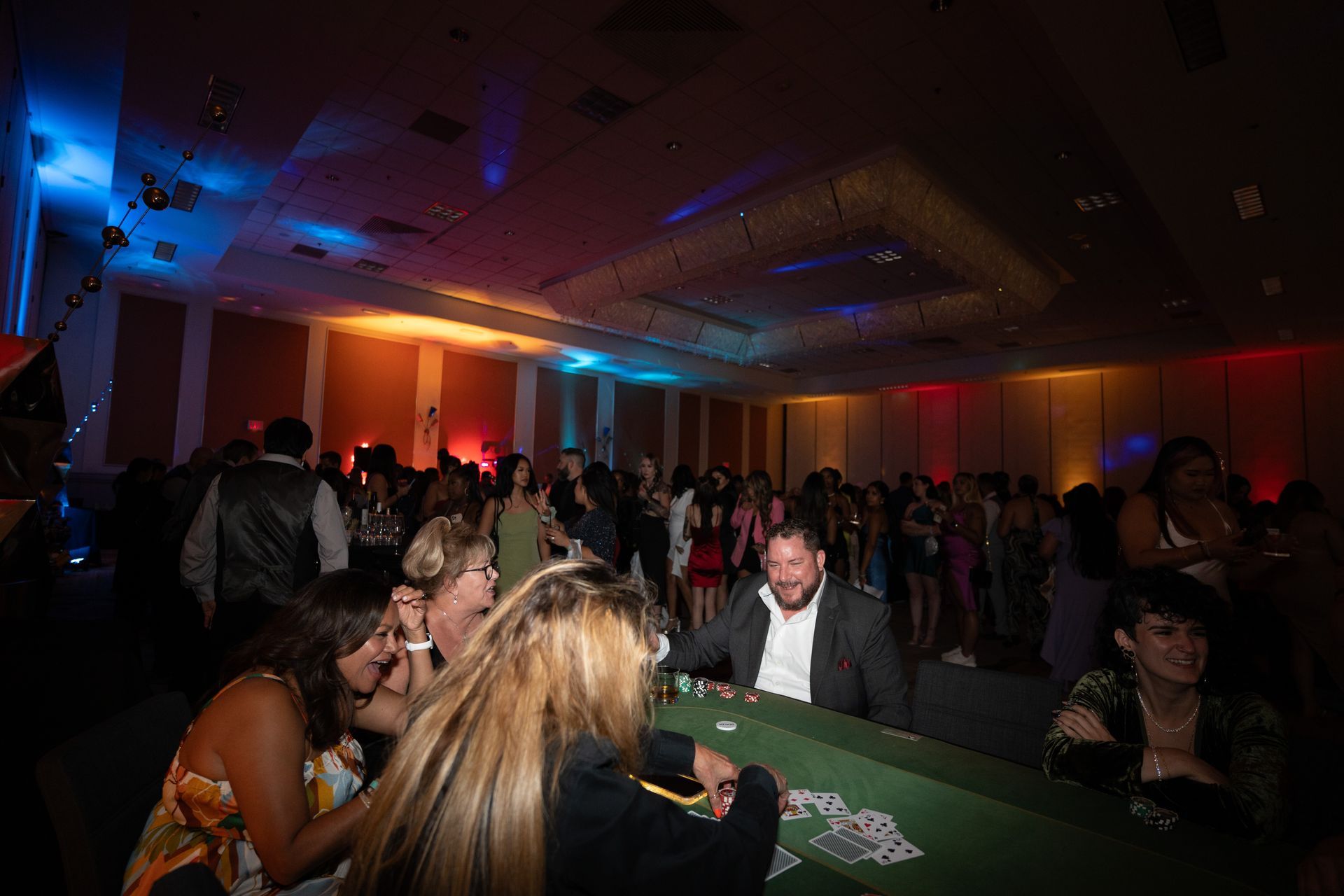 A group of people are playing a game of poker in a large room.