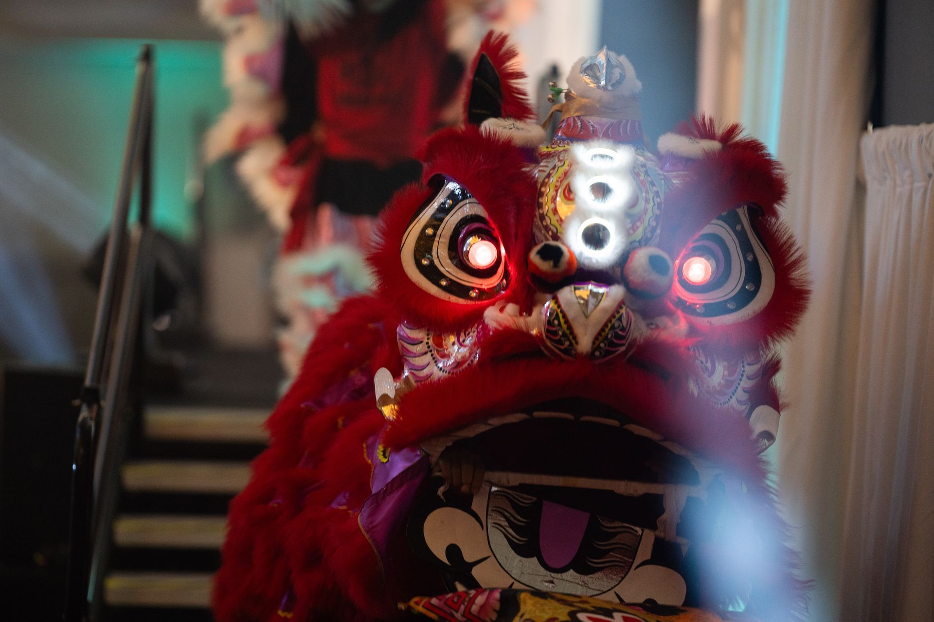 A close up of a red lion dancing in a room.