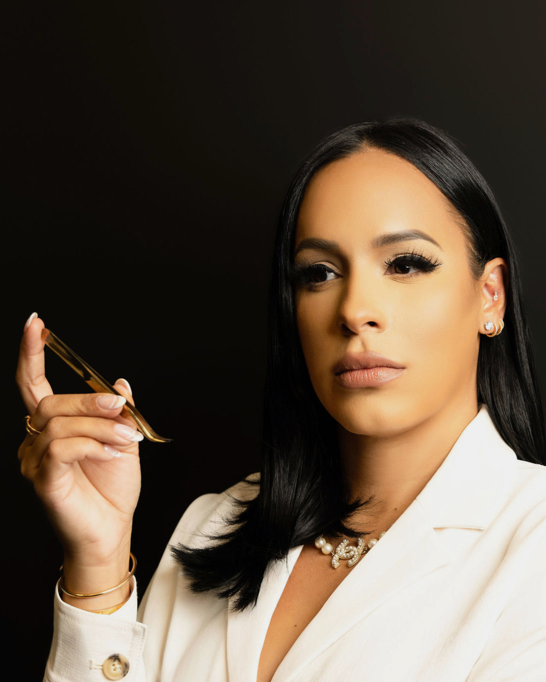 A woman in a white jacket is holding a pen in her hand.