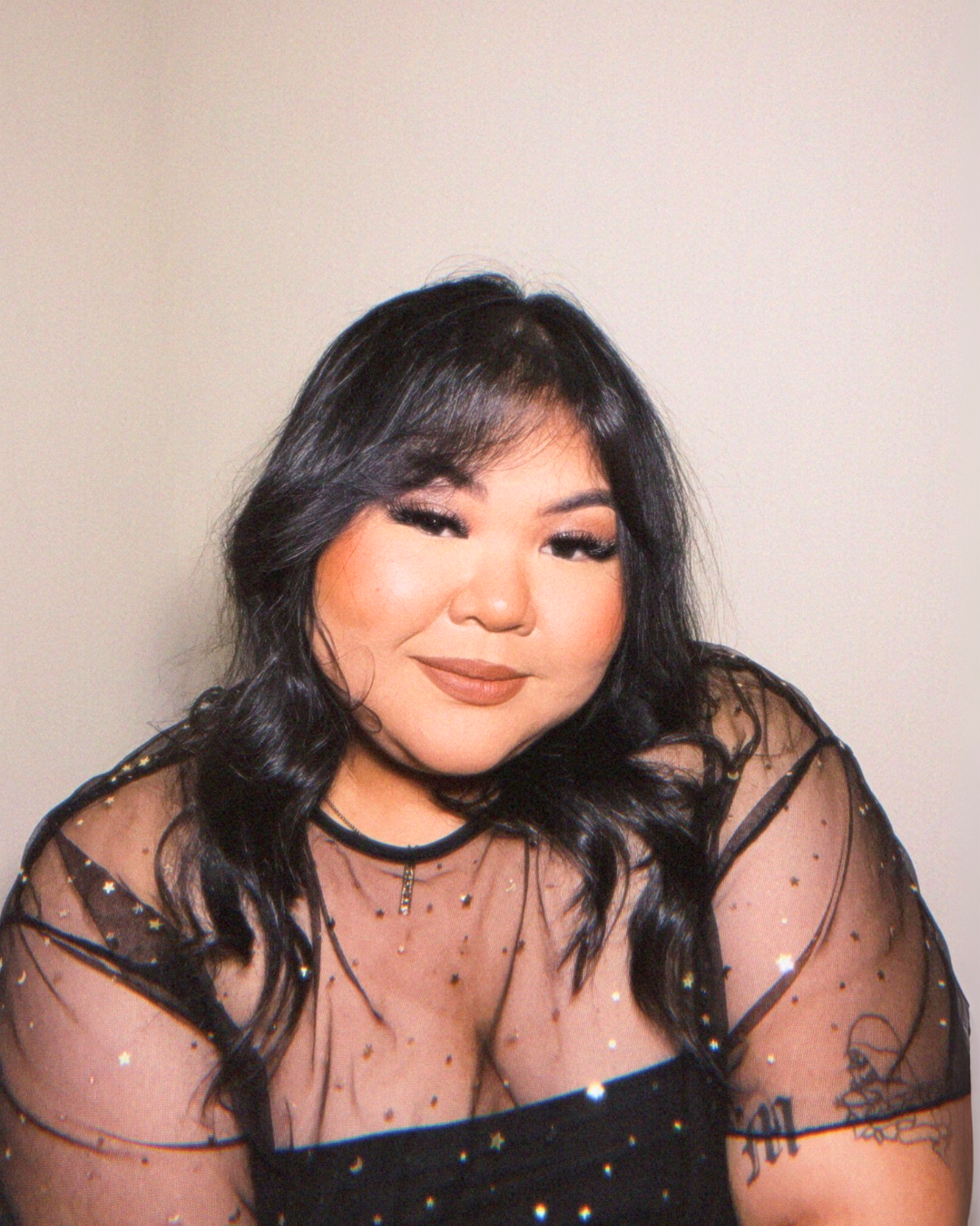 A woman in a black top is smiling for the camera.