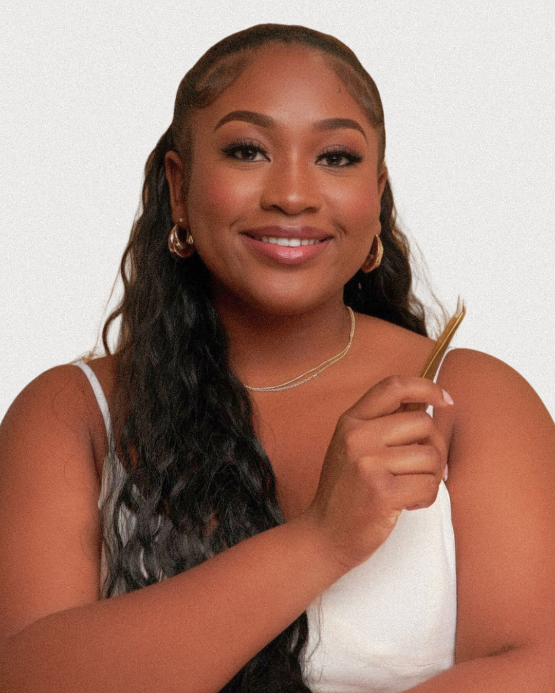 A woman with long hair is smiling and holding a comb