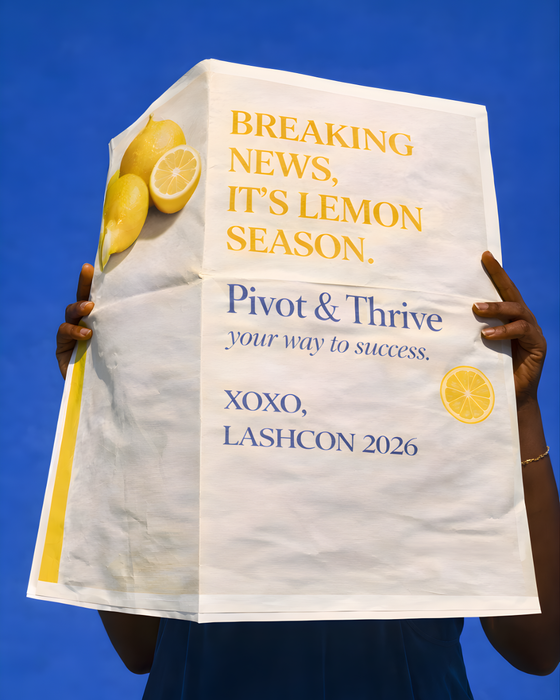 A person holds a white newspaper against a bright blue sky that reads, 