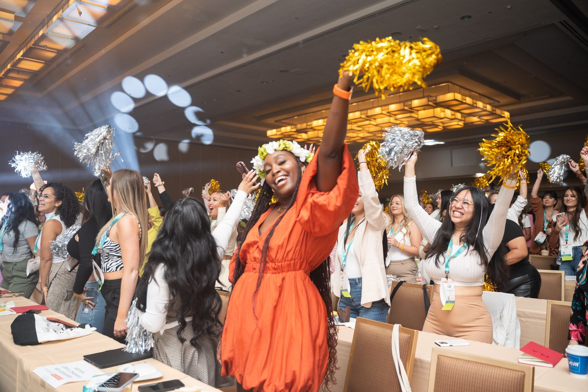 A group of women are standing in a room holding pom poms in their hands.