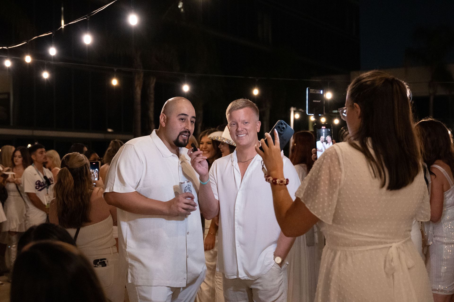 A woman is taking a picture of two men at a party.