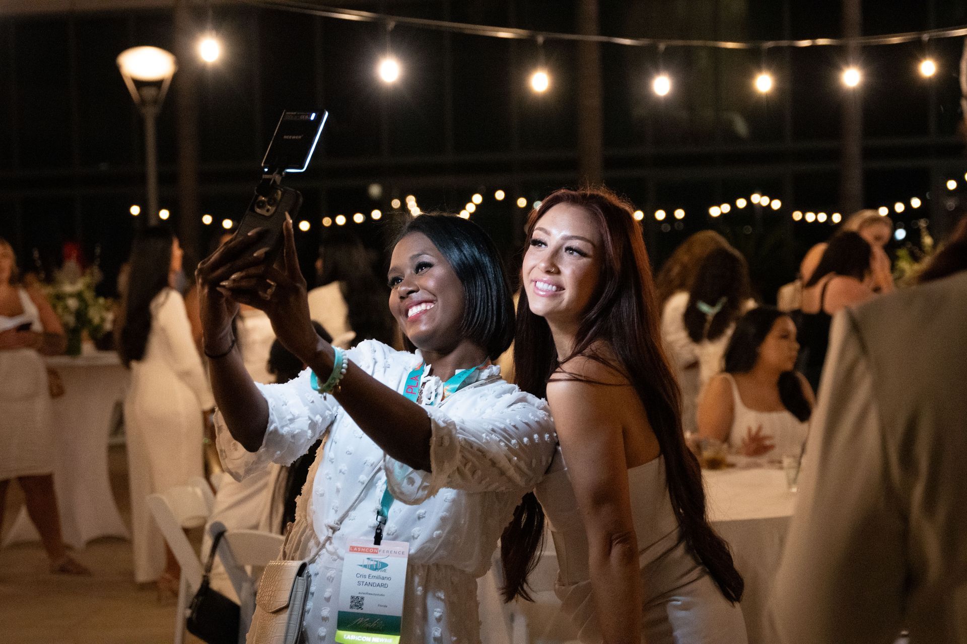 Two women are taking a selfie together at a party.