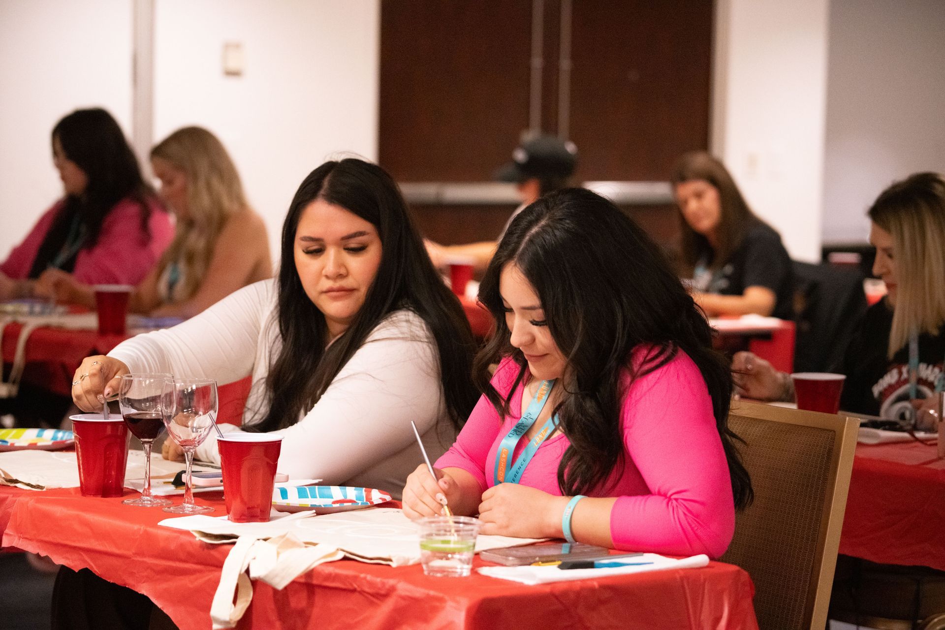 A group of women are sitting at tables in a room.
