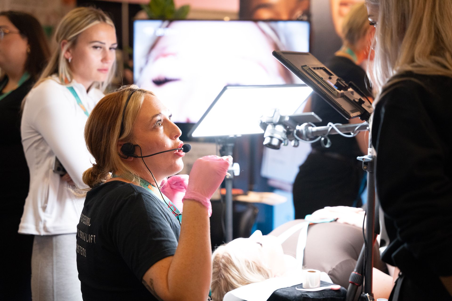 A woman wearing a headset and gloves is talking to another woman.