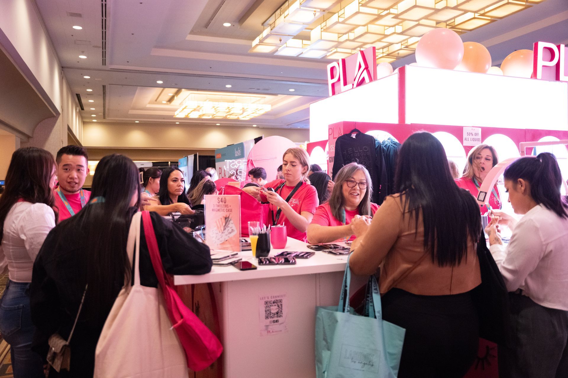 A group of people are standing around a table at a convention.