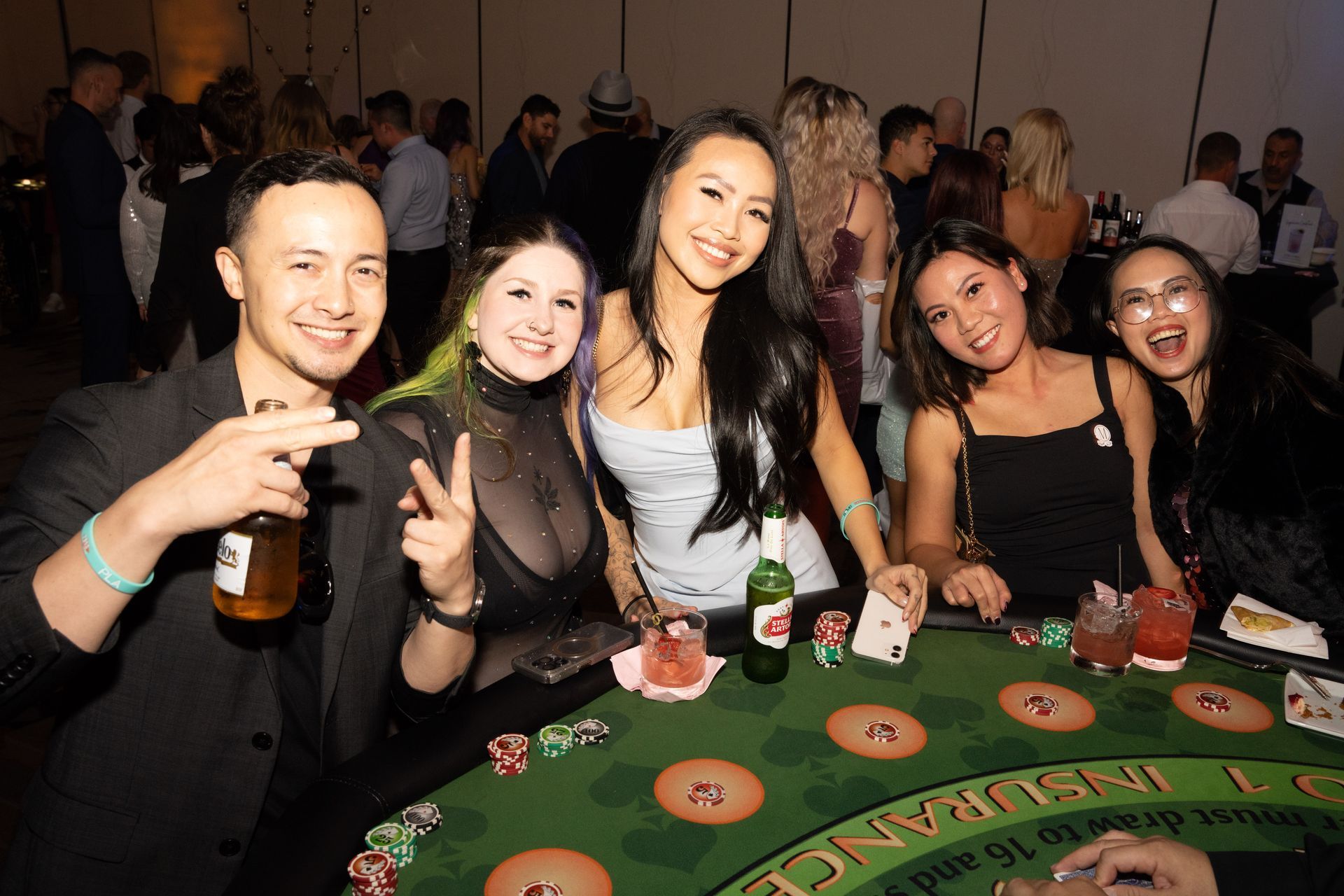 A group of people are posing for a picture at a poker table.