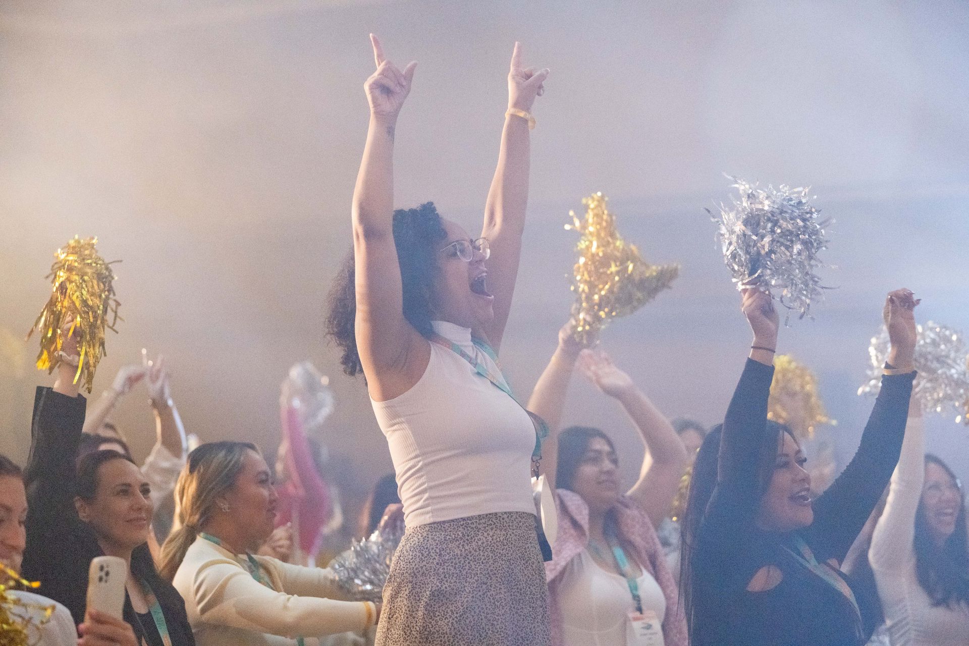 A group of women are dancing in a room with their arms in the air.