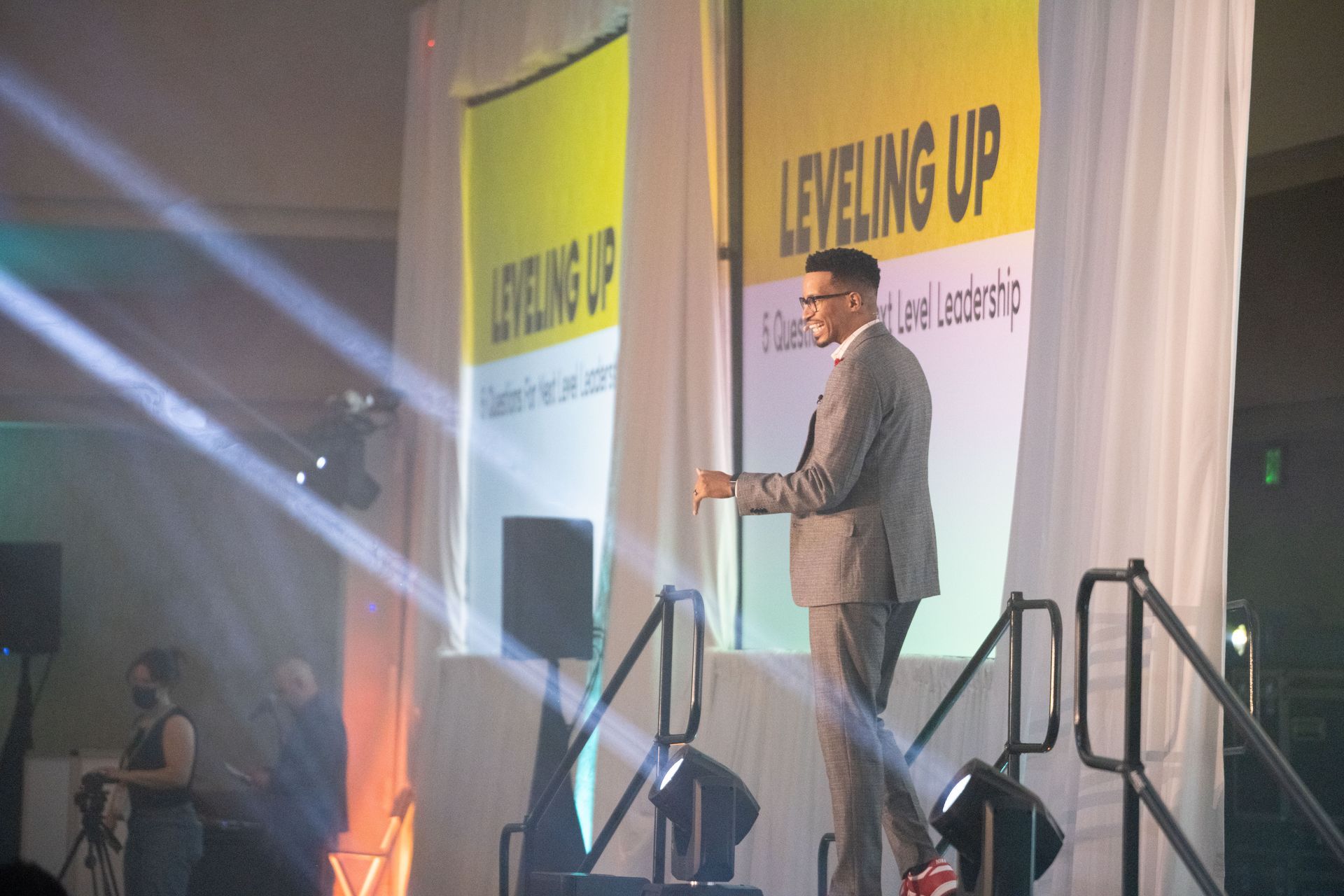 A man in a suit is standing on a stage giving a speech.