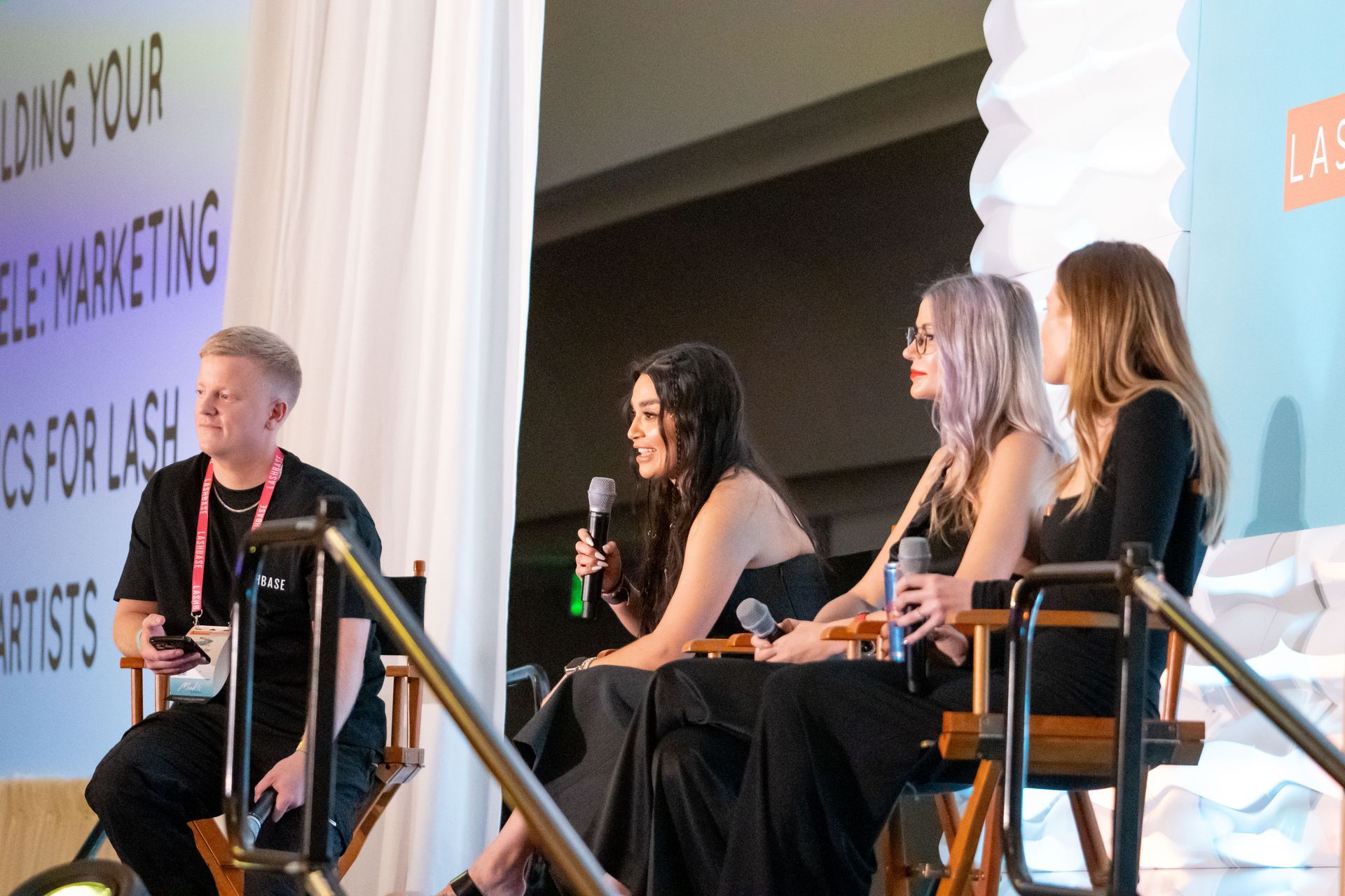 A group of people are sitting in chairs in front of a sign that says marketing