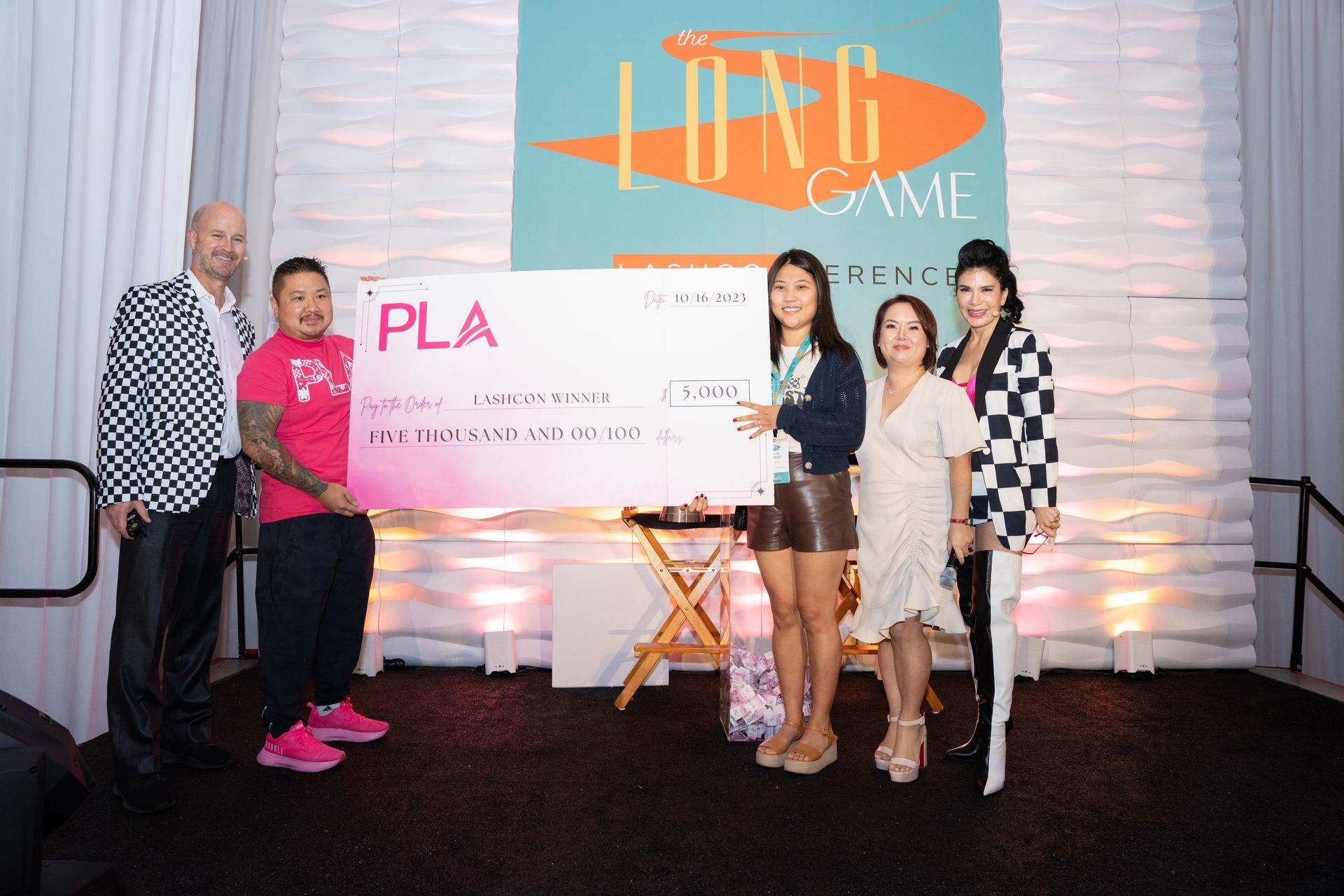 A group of people standing next to each other holding a large check.