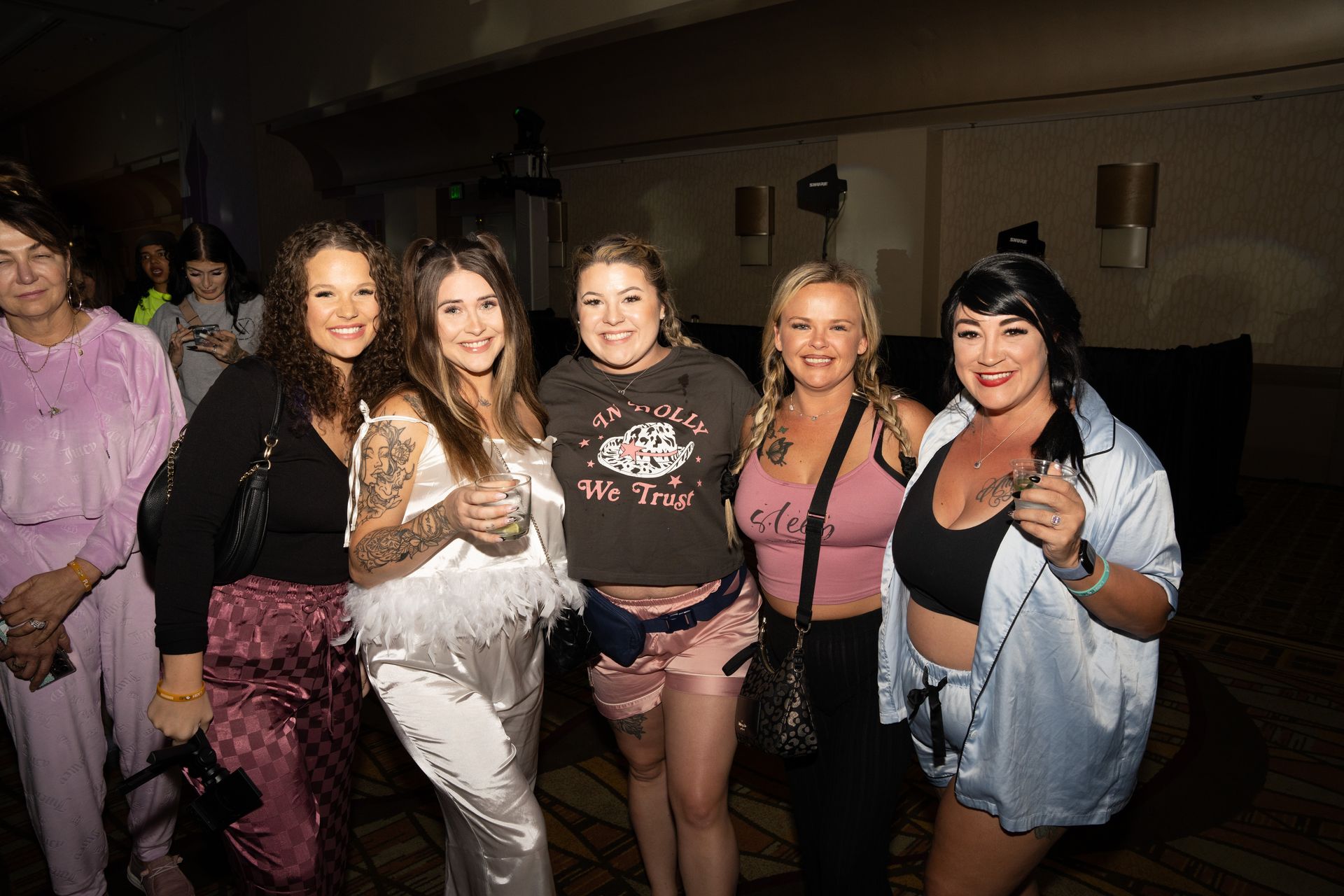 A group of women are posing for a picture together in a room.