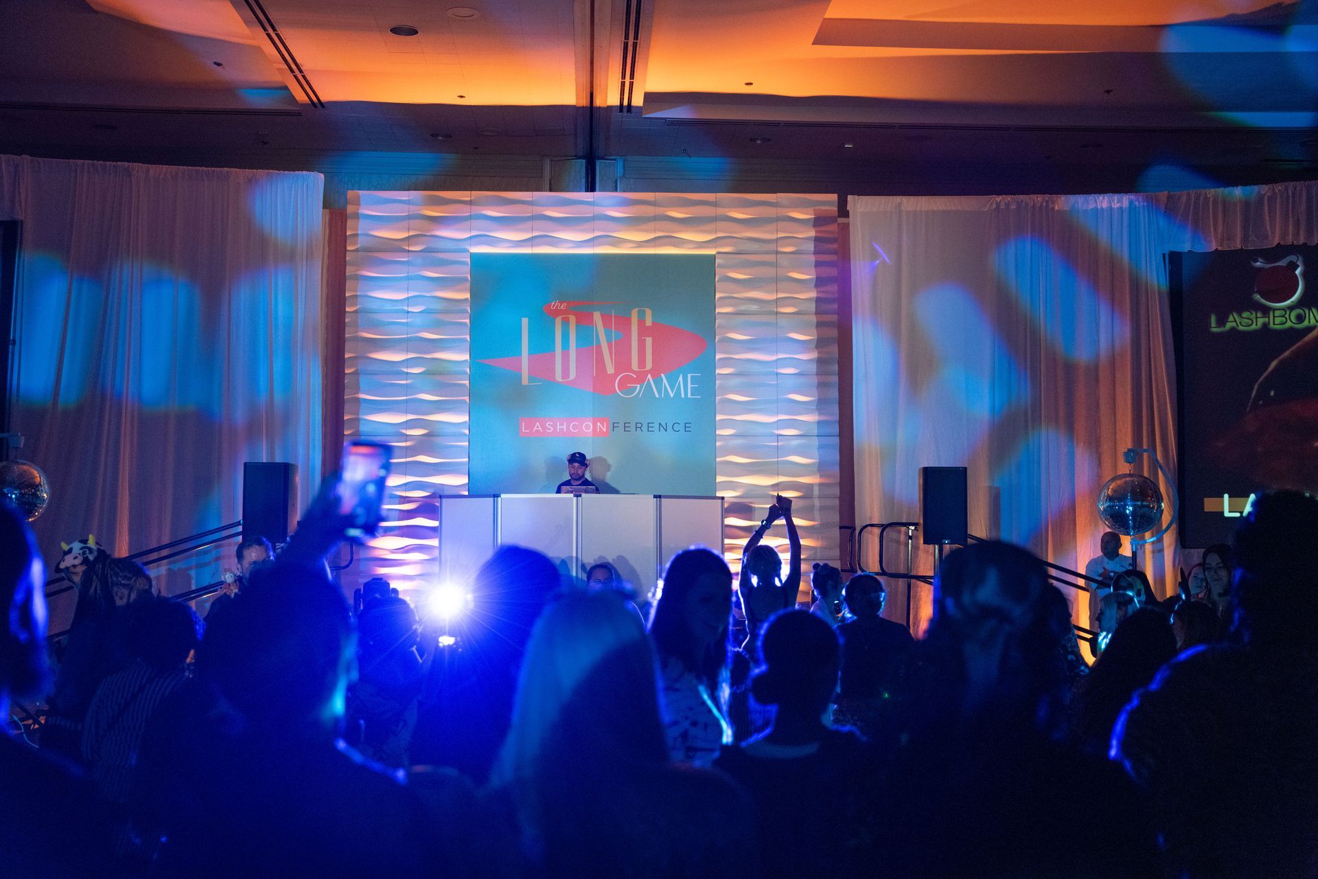 A dj is playing music in front of a crowd of people at a party.