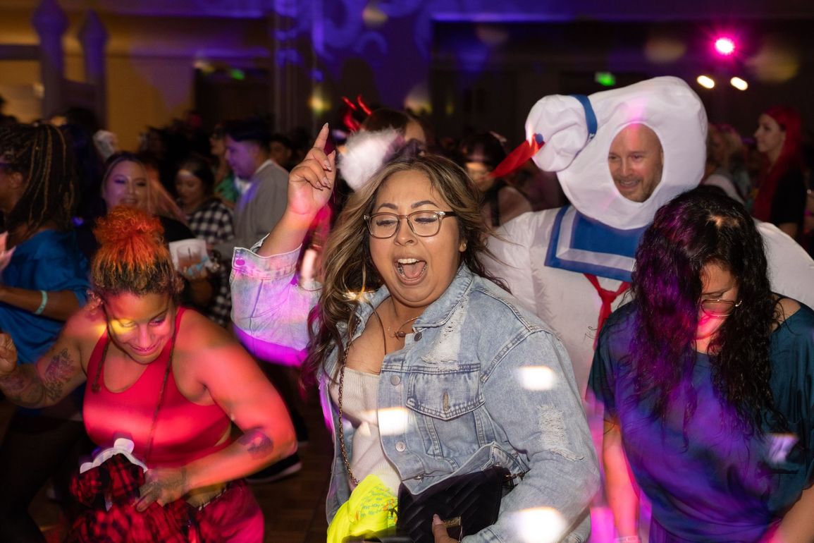 A group of people dressed in costumes are dancing at a party.