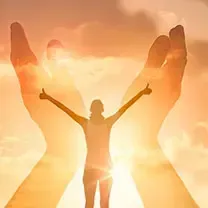 A woman is standing in front of a sunset with her arms outstretched.