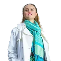 A woman wearing a white coat and a blue scarf.