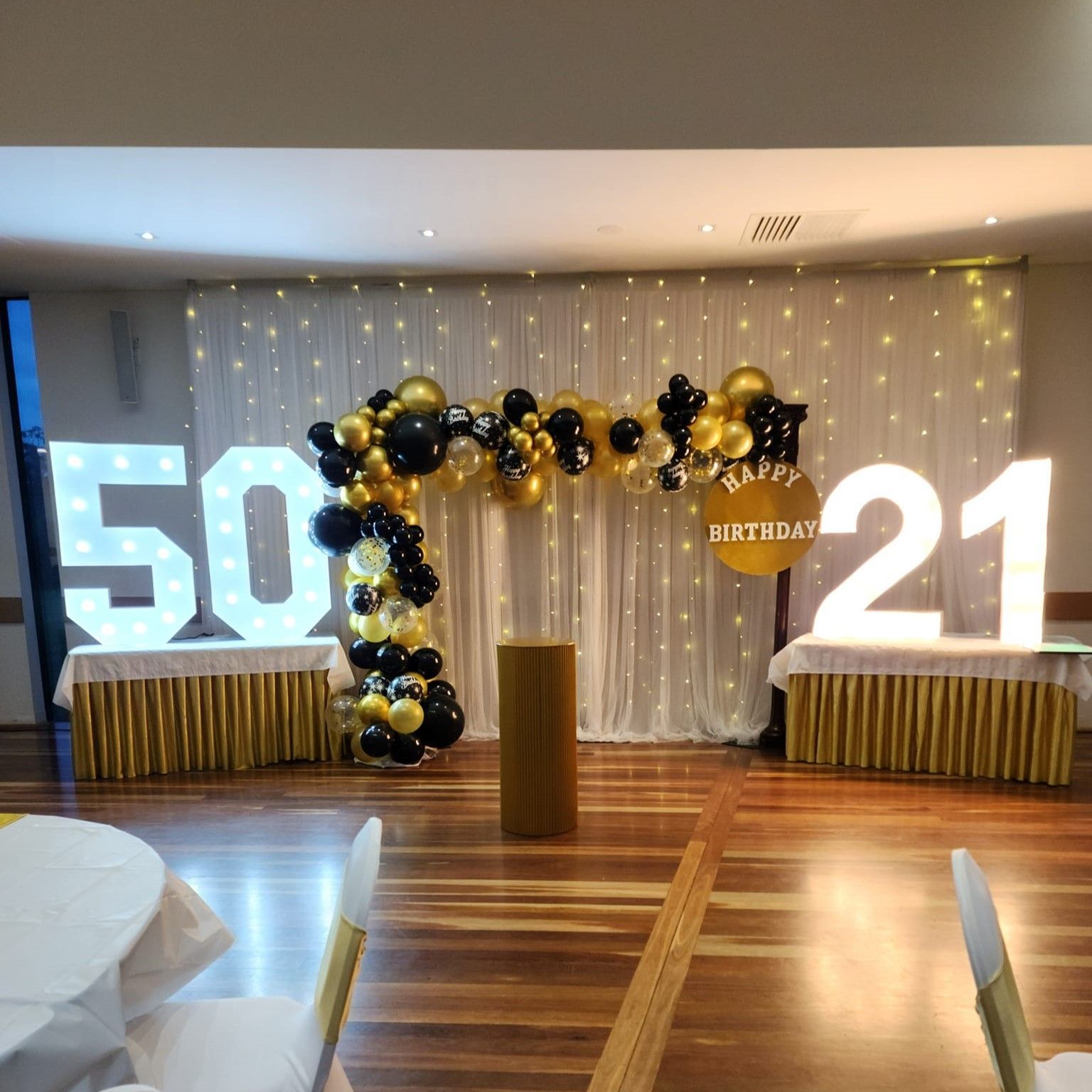 A room decorated with balloons and a sign that says 50 and 21