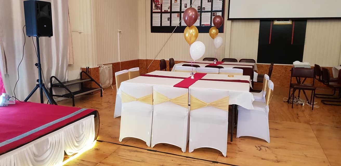 A large room with tables and chairs set up for a party.