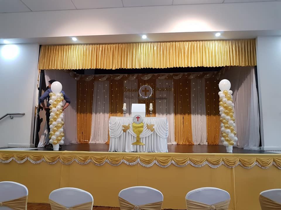 A stage with balloons and a chalice on it