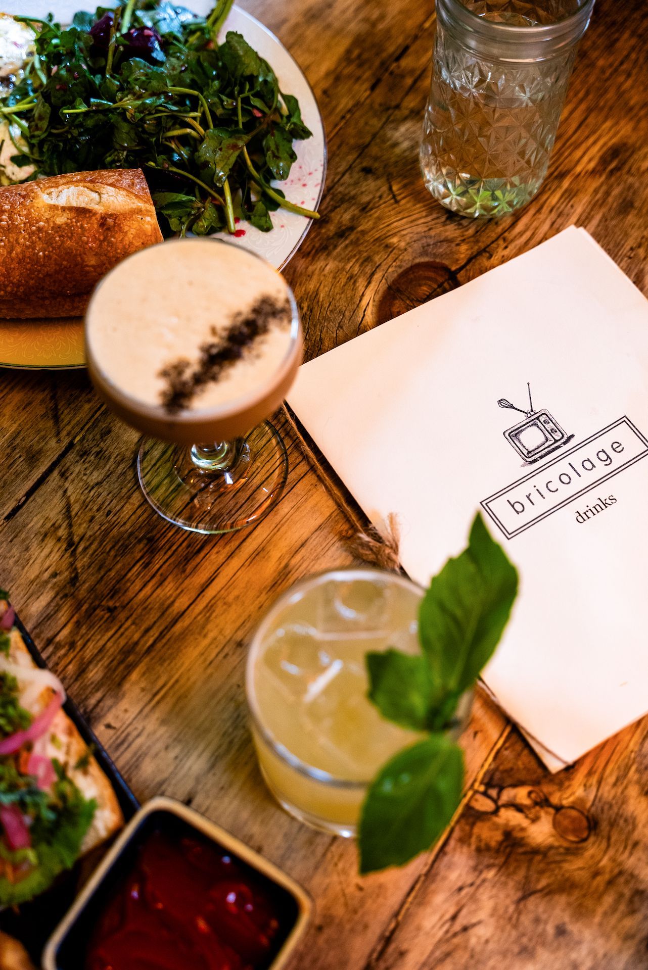 A wooden table topped with a variety of food and drinks.
