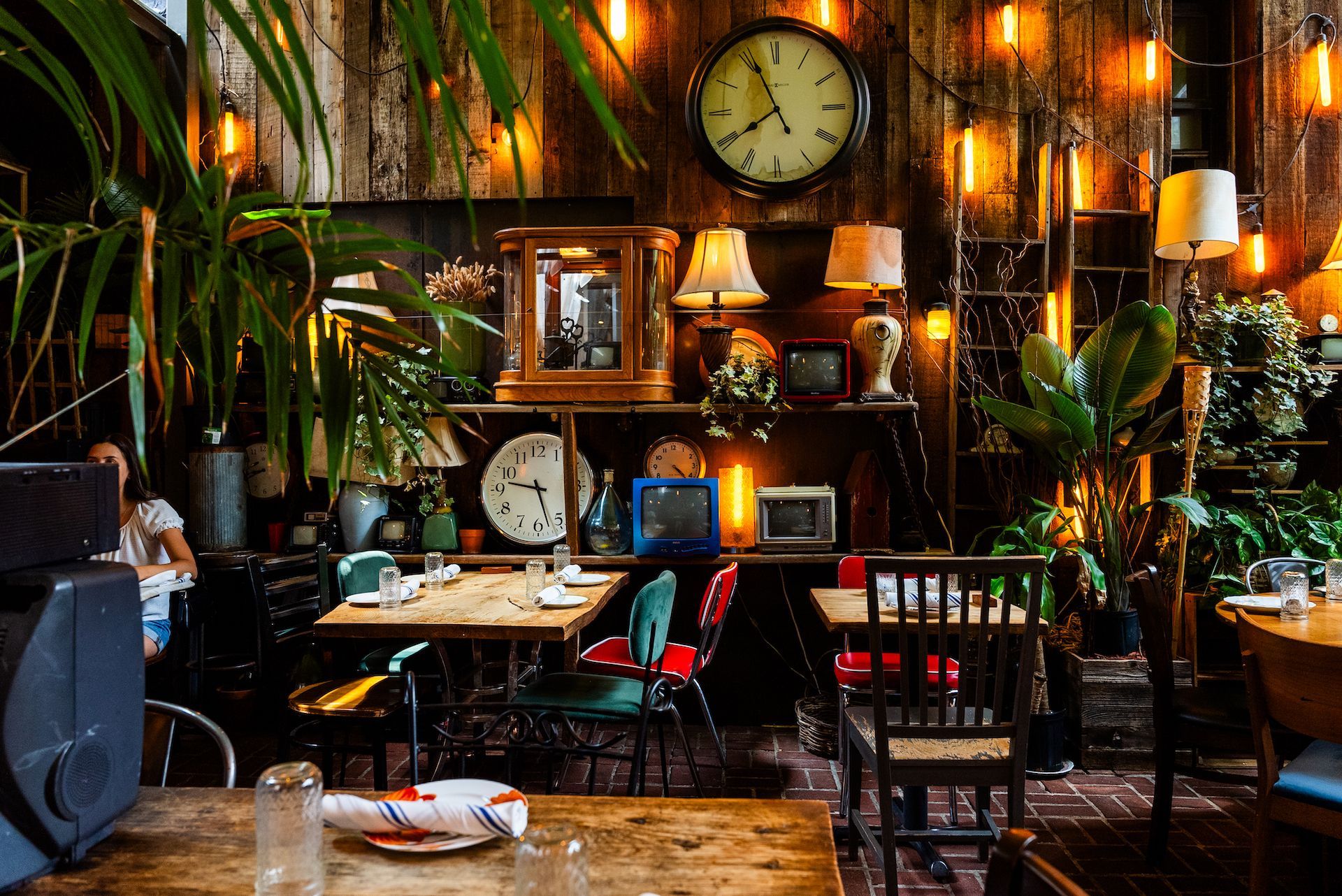 A restaurant with tables and chairs and a clock on the wall