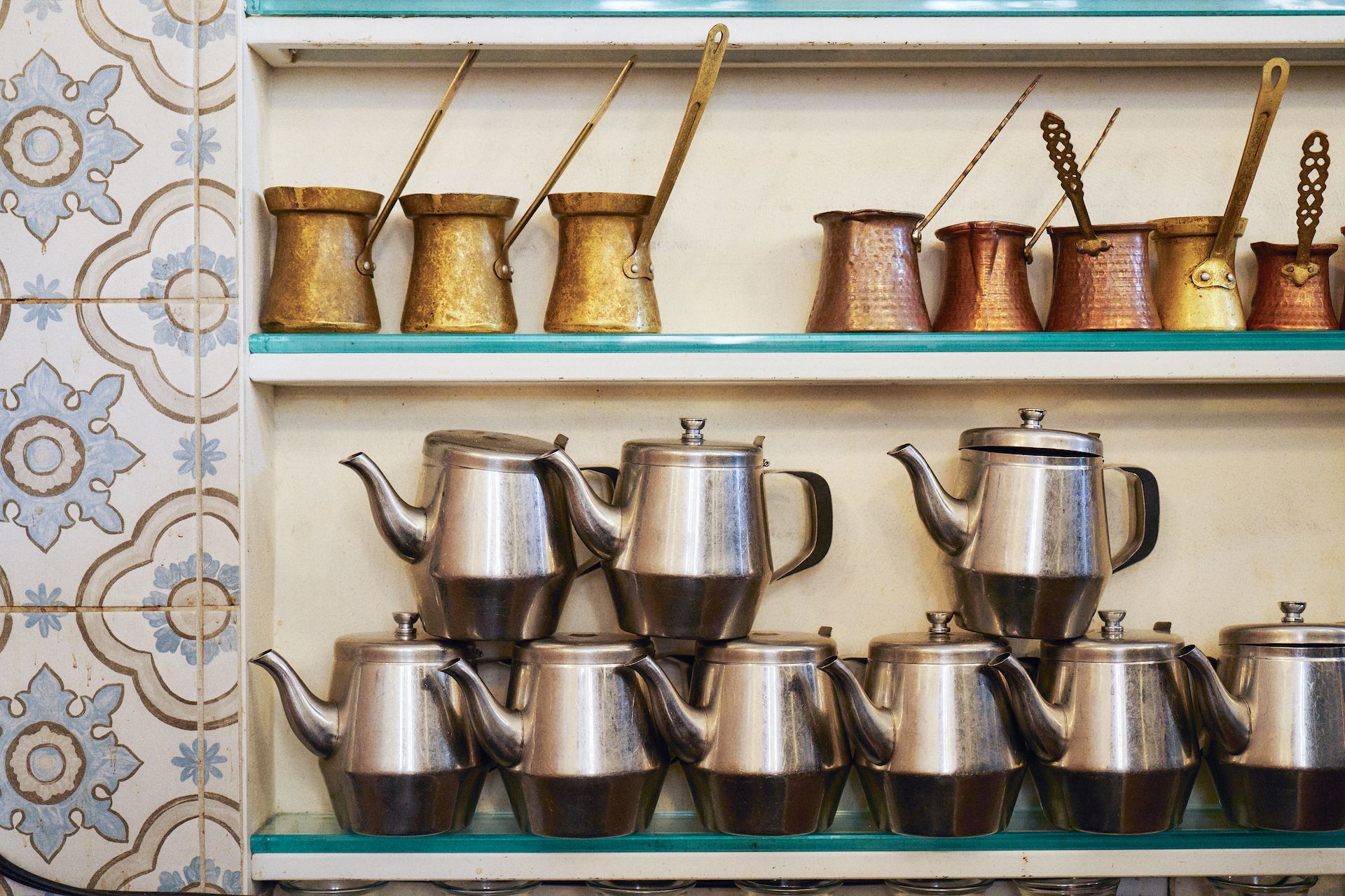 A shelf filled with a variety of teapots and coffee pots.