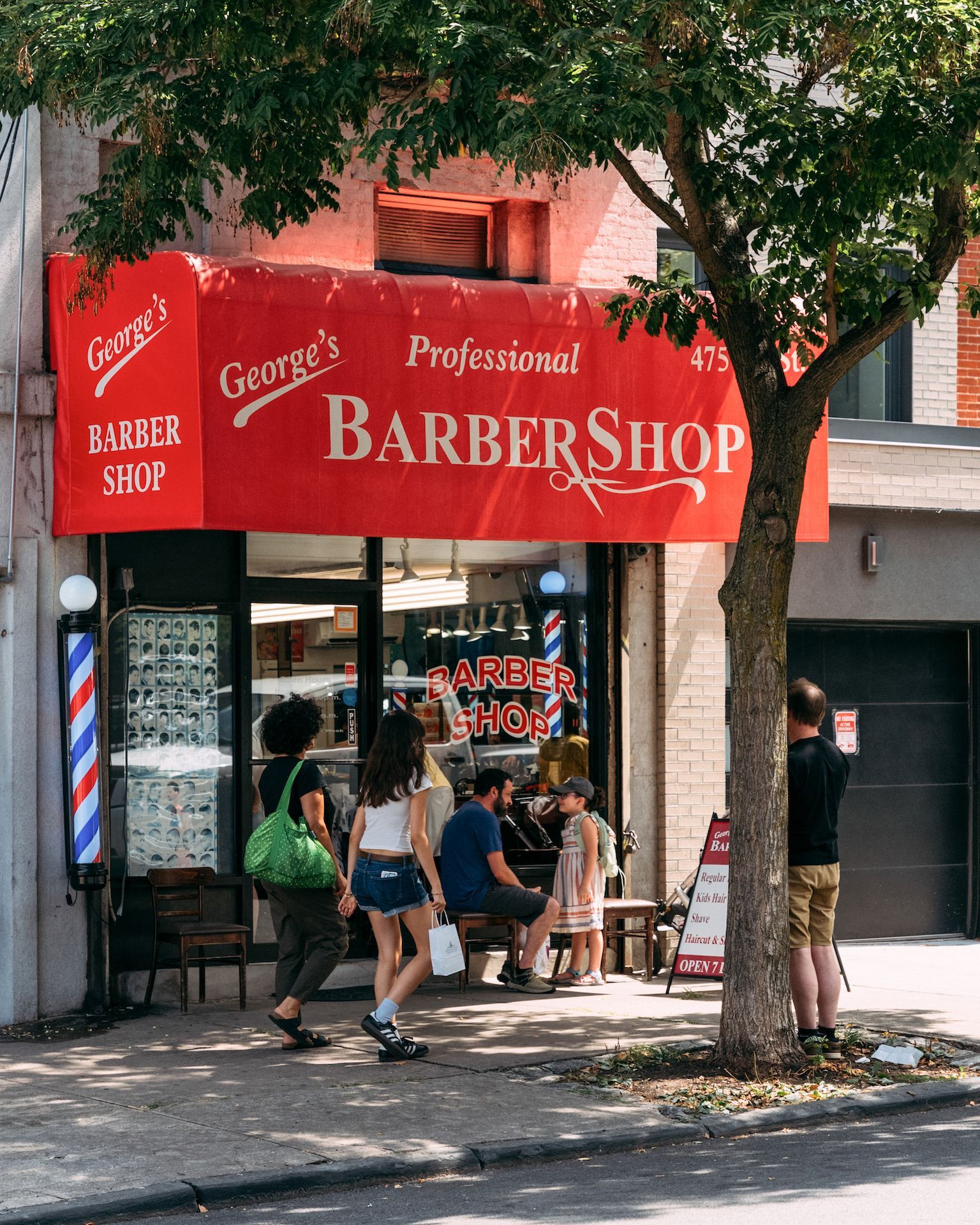 A group of people standing outside of a barber shop